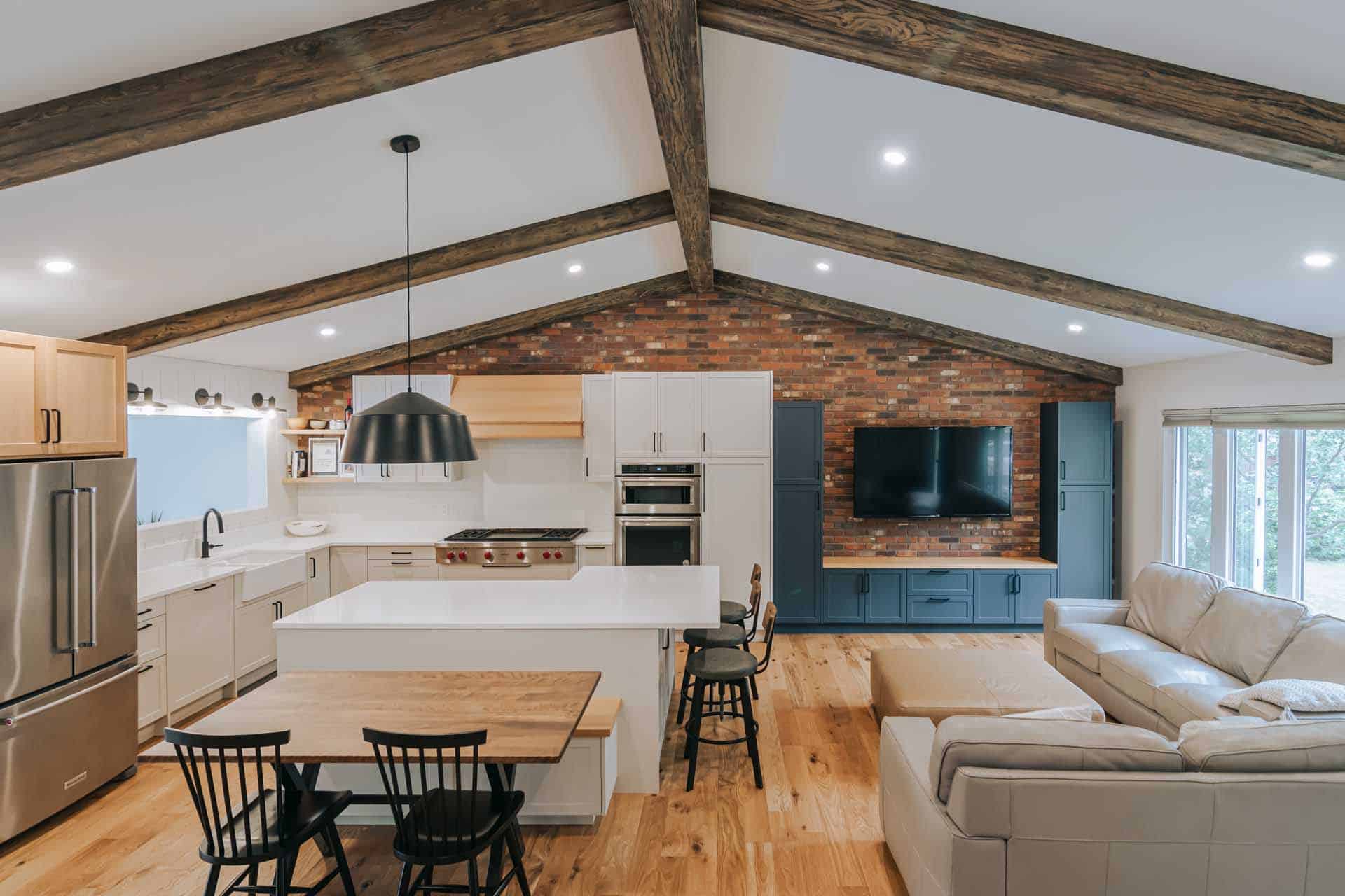 open floor plan kitchen and living room with exposed beams and solid hardwood flooring