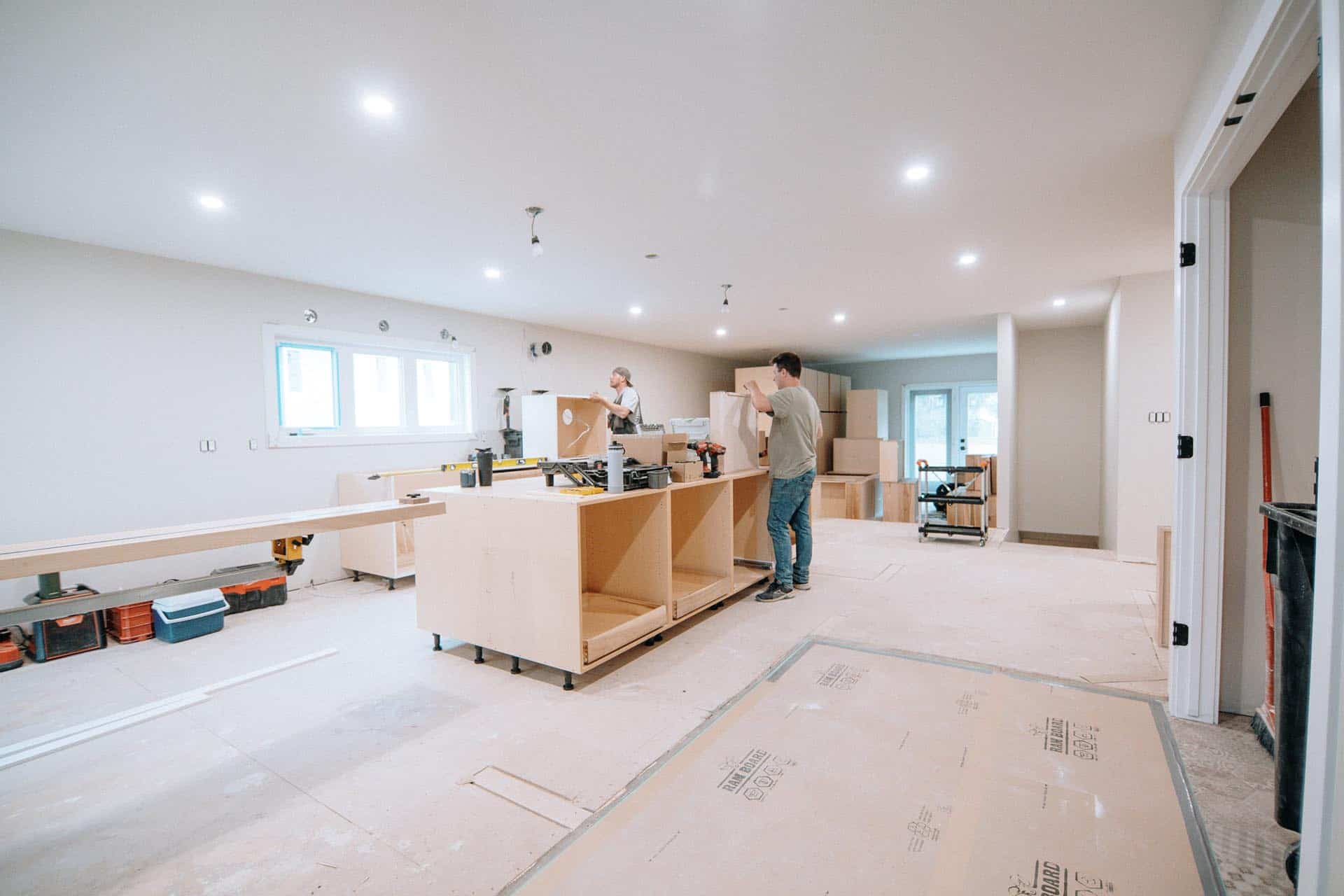 workers assembling cabinetry in a clean renovation project with floor protection