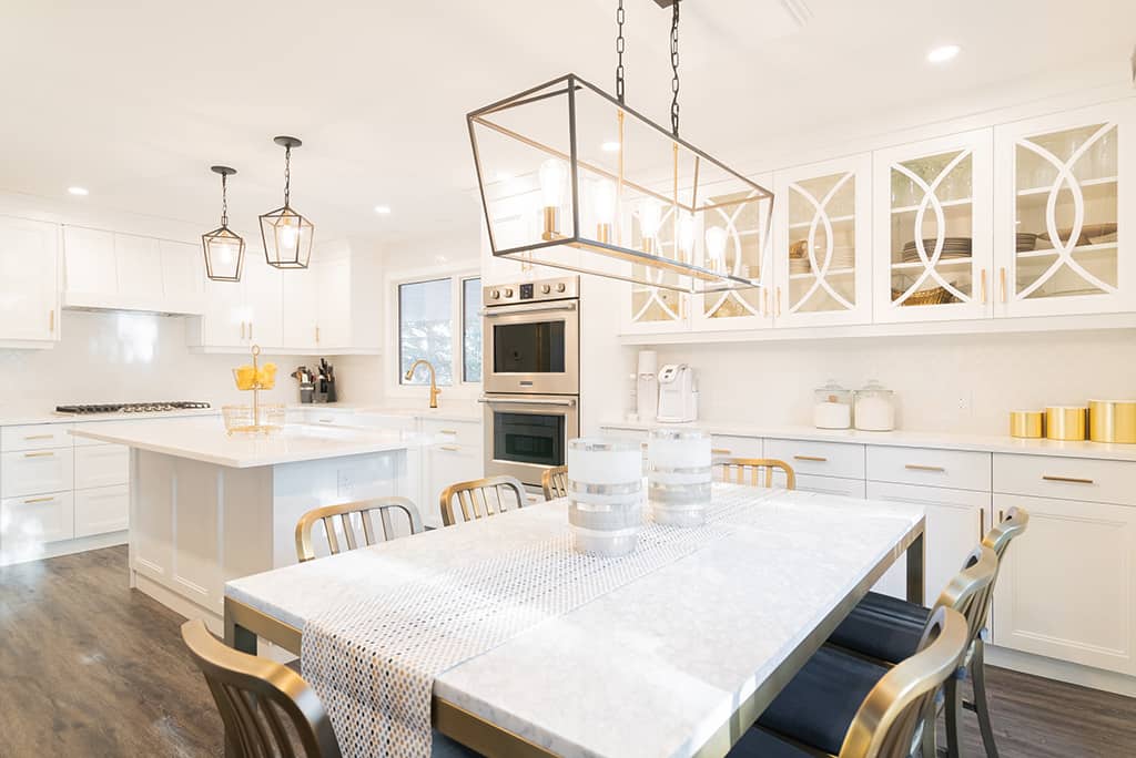 bright white kitchen with gold accents and ornate cabinet details