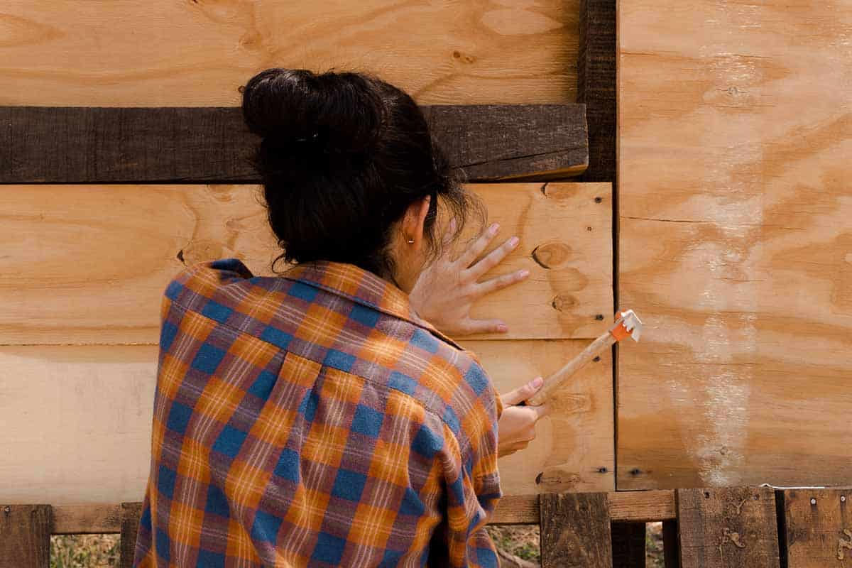 handywoman hammering a board into place