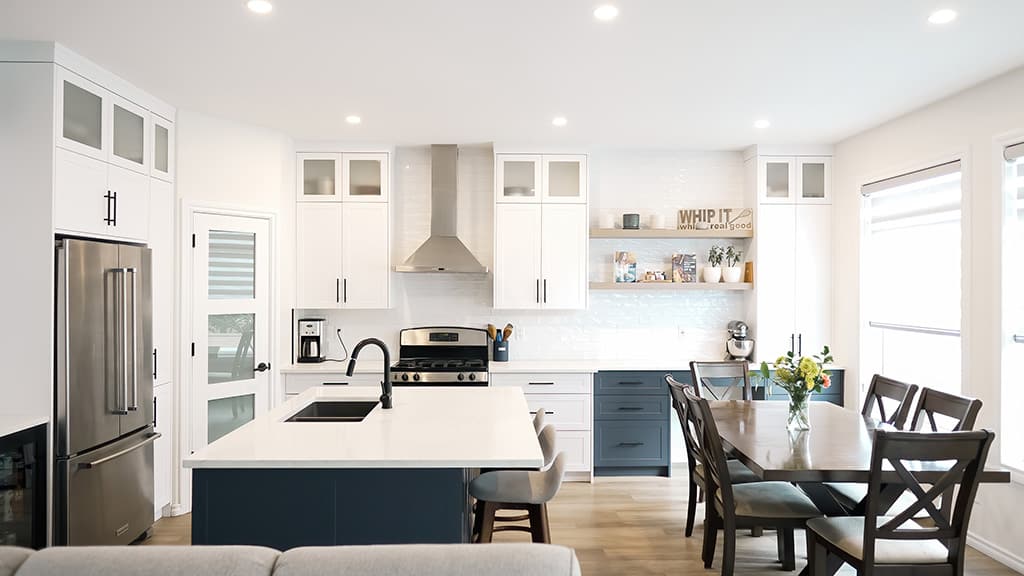 bright white kitchen with granite countertop and navy bottom cabinets